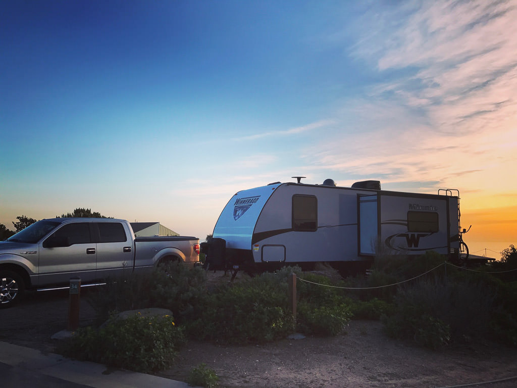Winnebago Minnie towable parked in campsite.