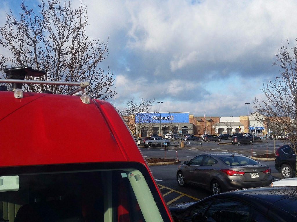 Winnebago Travato parked at the back of a Walmart parking lot.