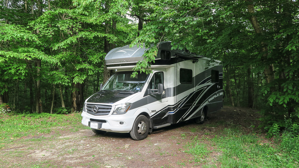 Winnebago View parked next to the trees.