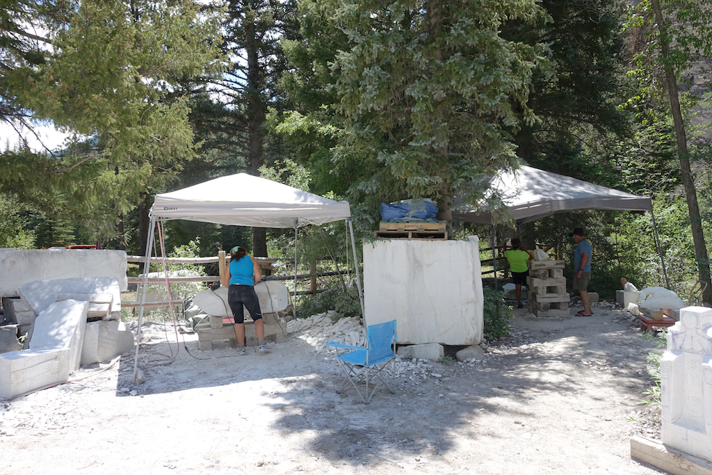 Two tents with sculptors working beneath them.