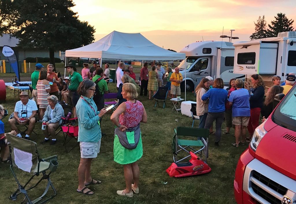 Group of people gathered among motorhomes.