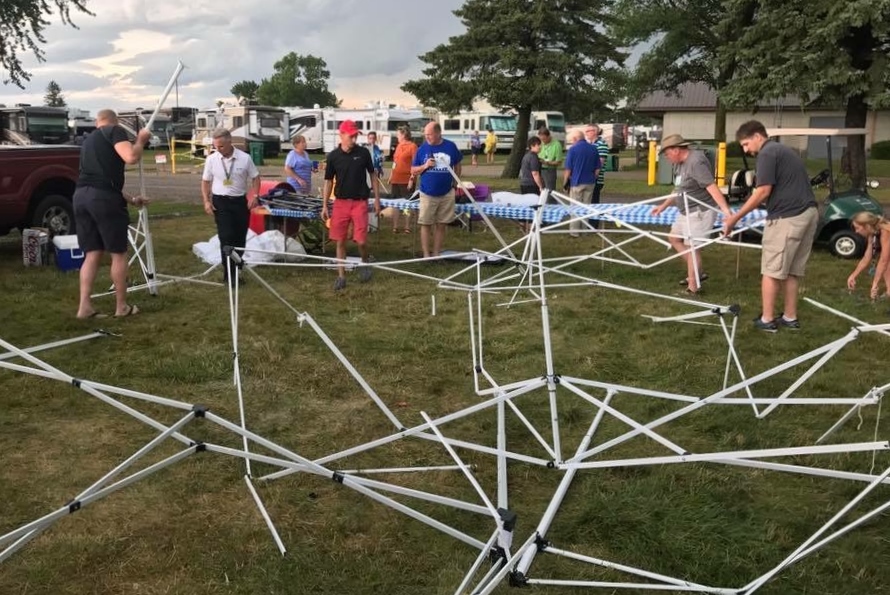 People picking up destroyed tent.
