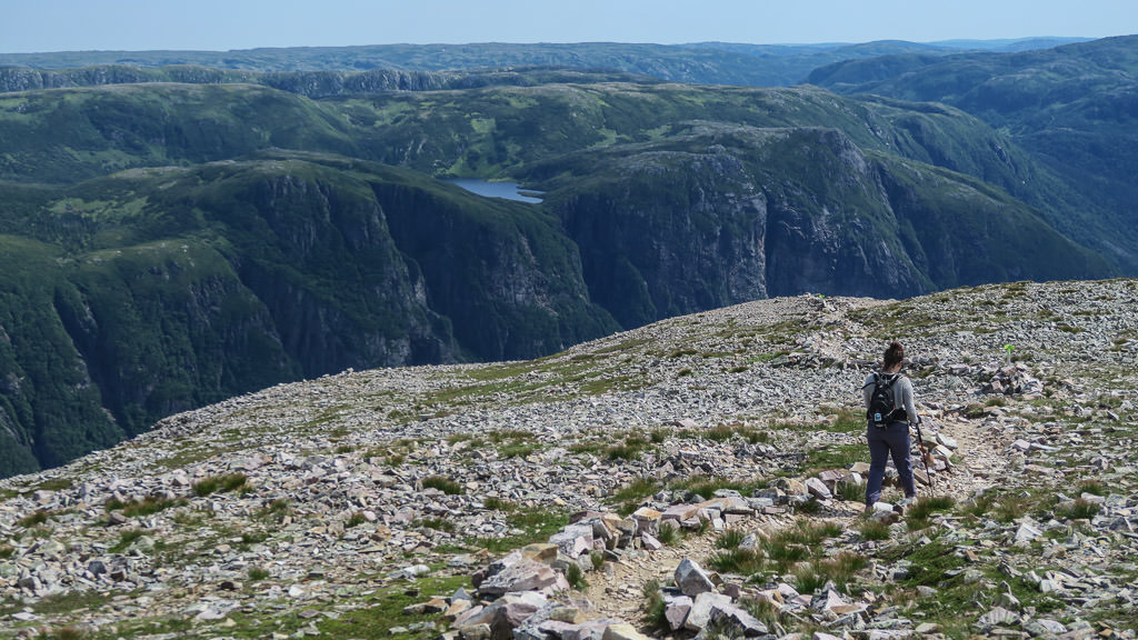 Woman hiking along steep hillside.