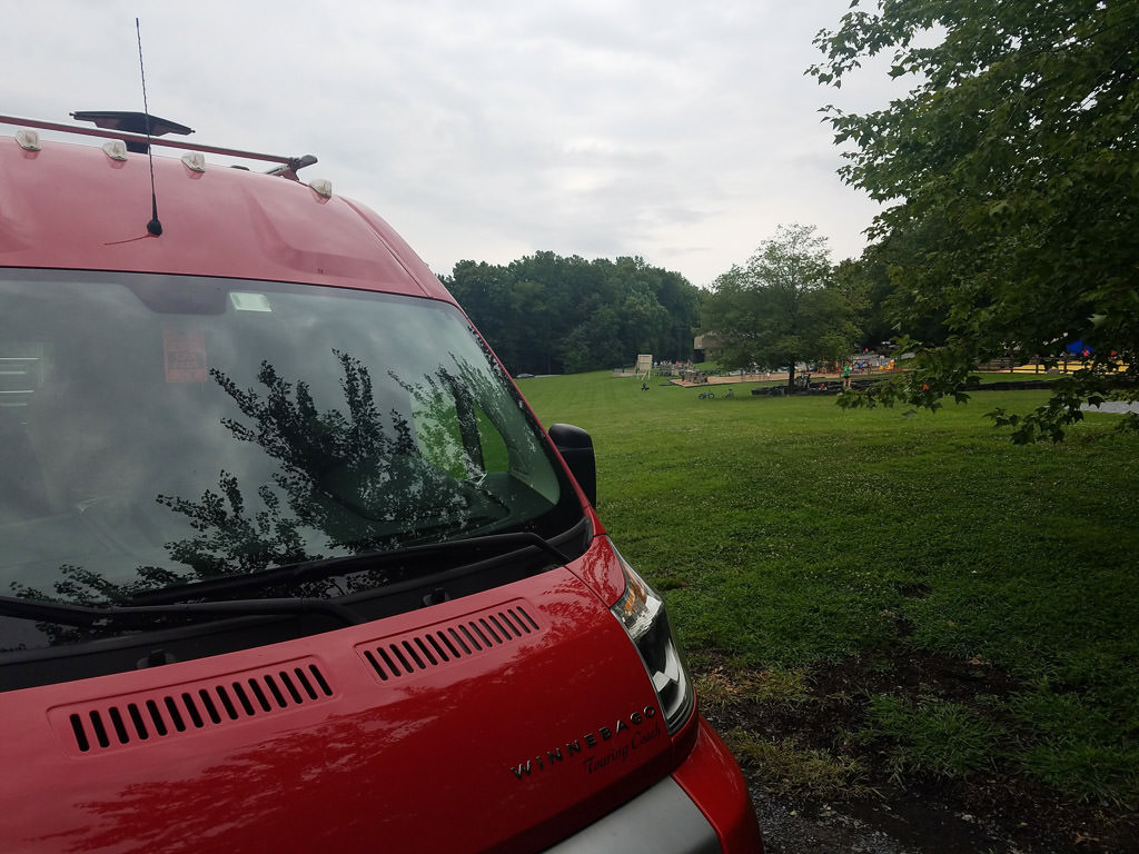 Winnebago Travato parked at a campground
