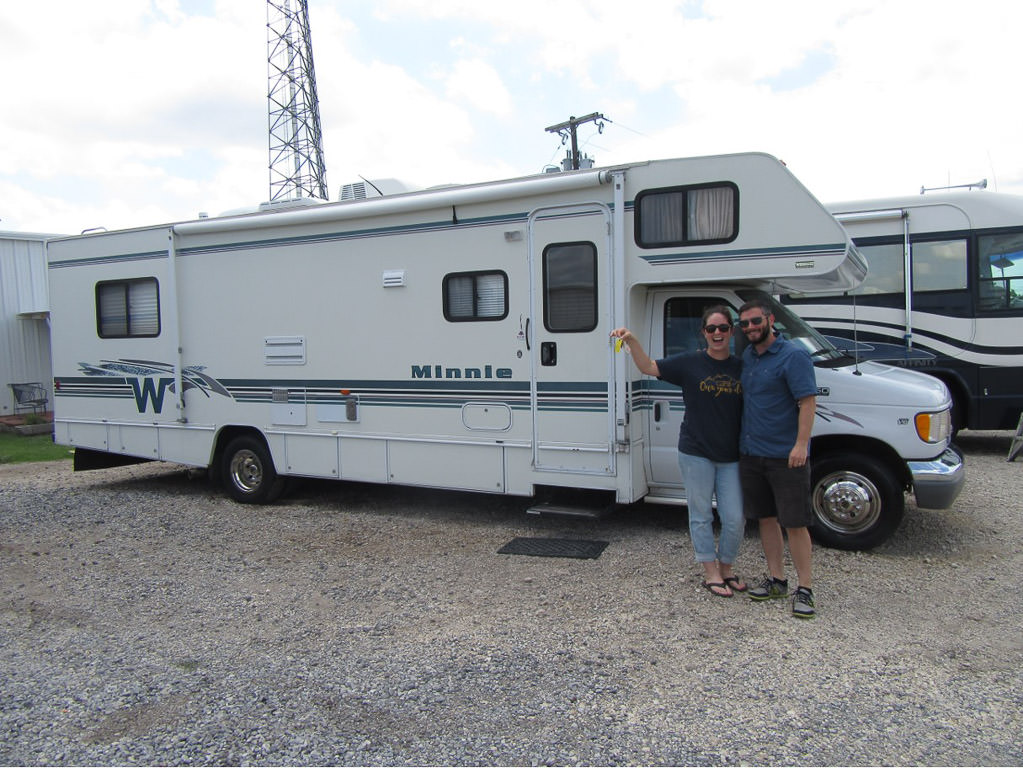 Couple holding keys outside Winnebago Minnie.