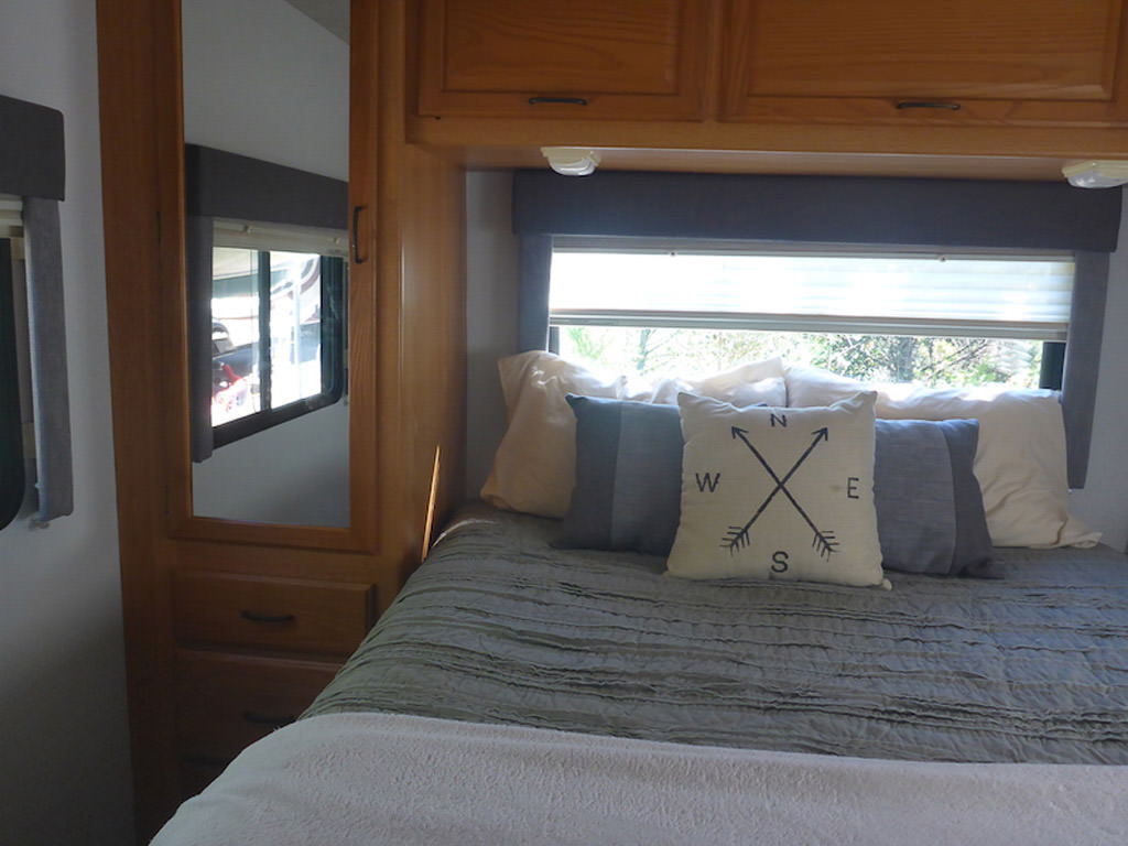 Back bedroom with homey bedding and pillows.