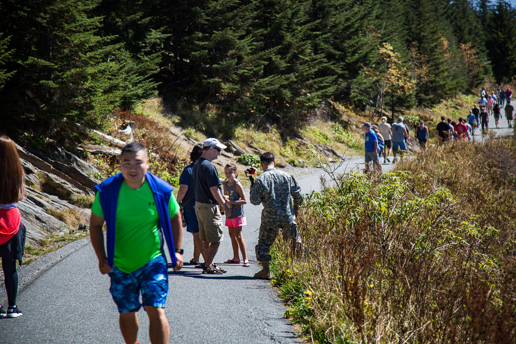 Large crowd of people along paved path. 