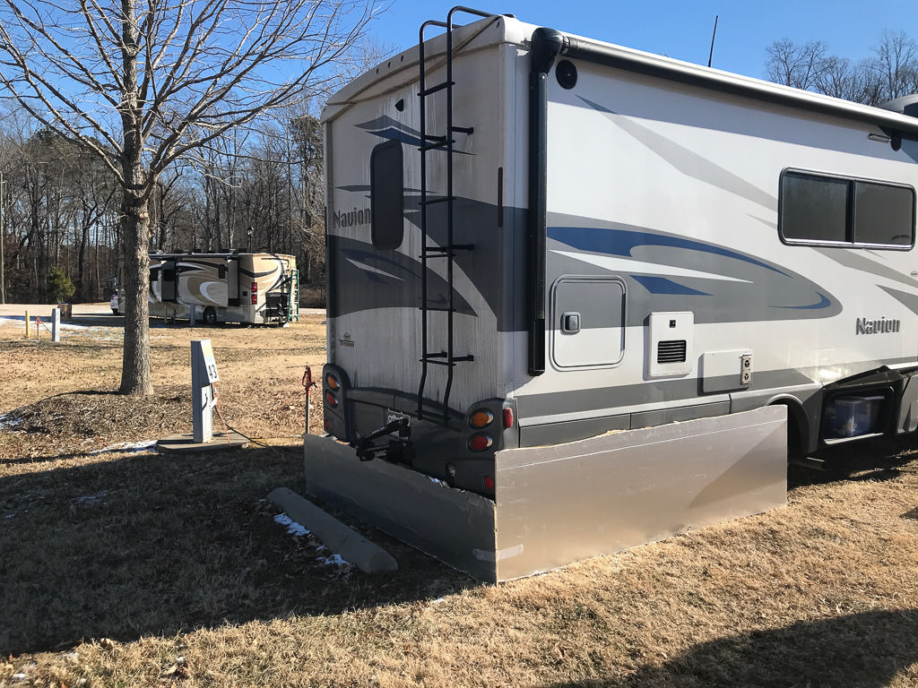 Winnebago Navion parked at a campground