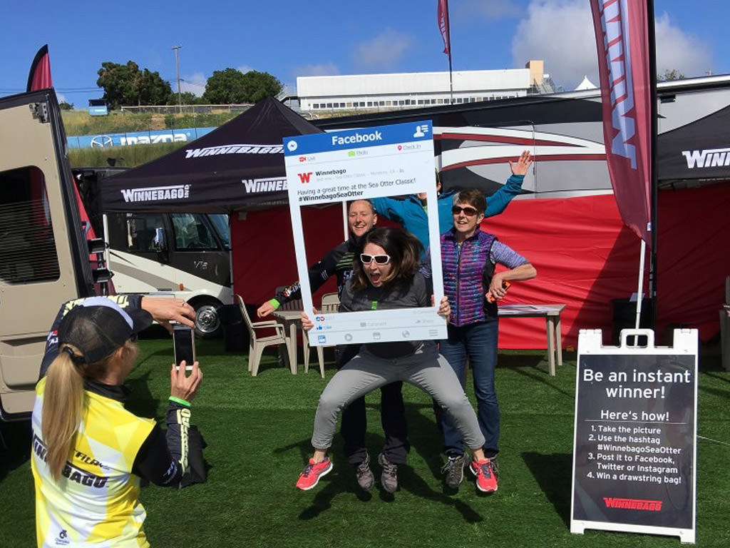 People taking photos in front of the Winnebago display at the Sea Otter Classic