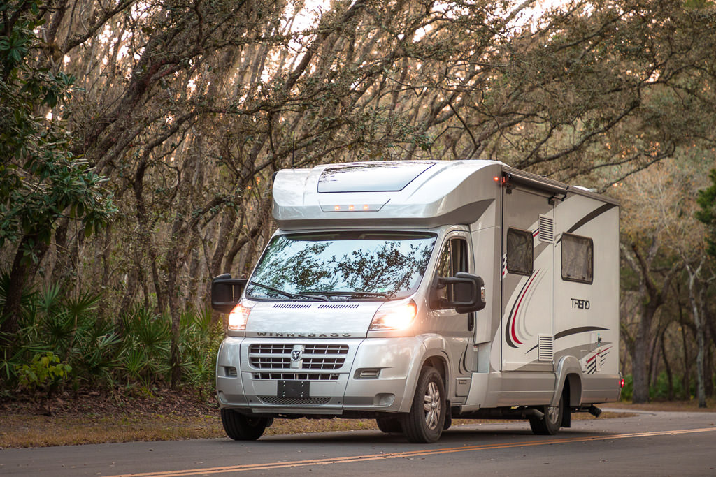 Winnebago Trend driving down tree lined road
