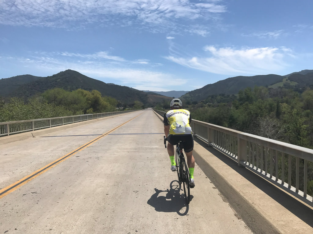 James biking across bridge wearing Winnebago biking gear