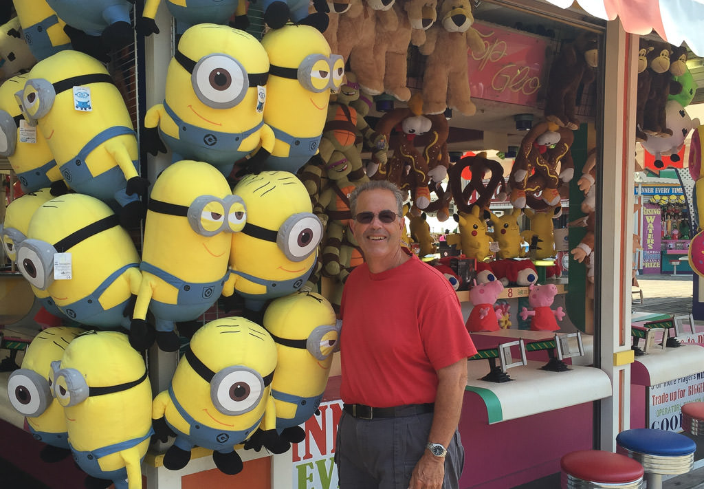 Man posing with carnival stuffed animal prizes