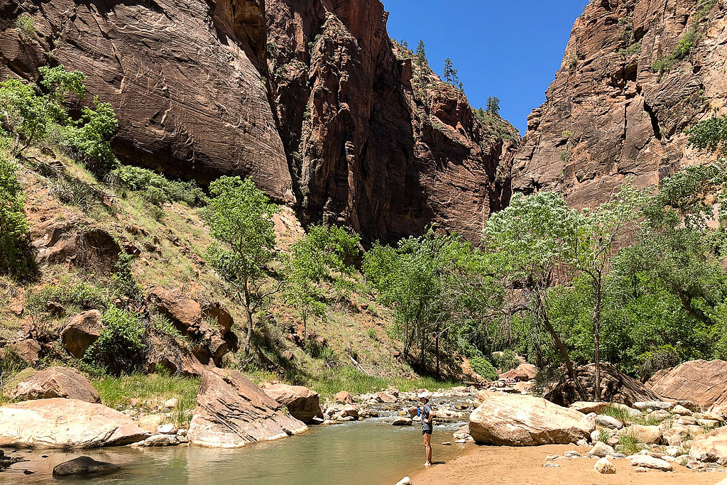 Brittany standing in the shallow river flowing through the canyon
