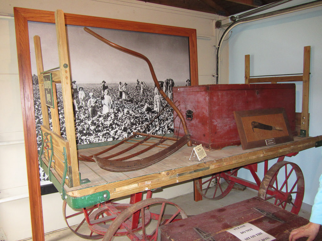 Old wooden cart with old farming item and chest resting on top.