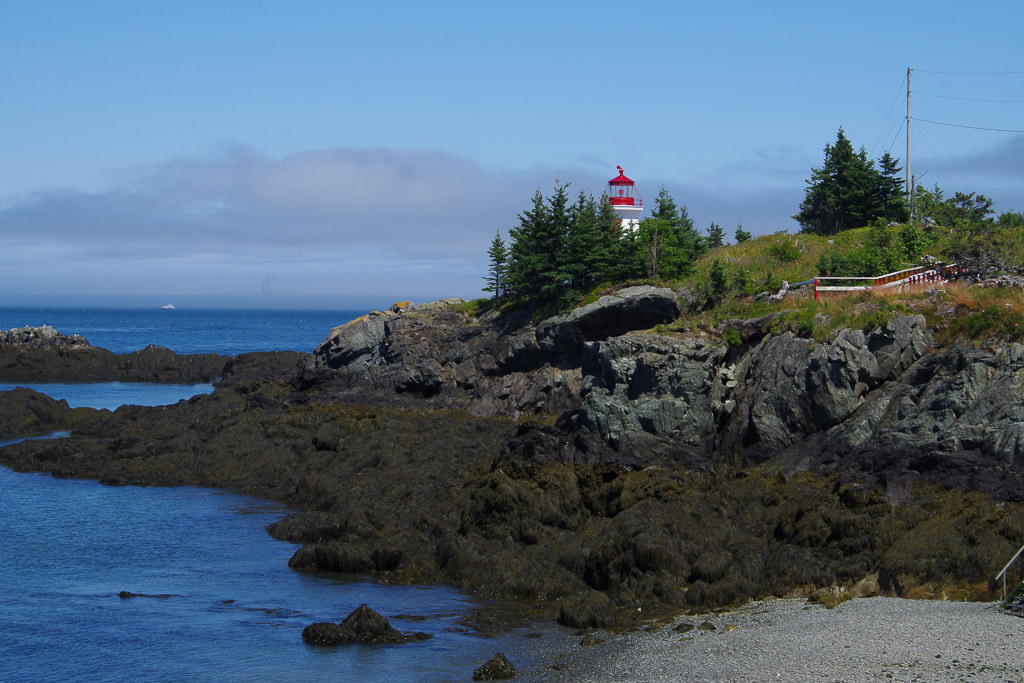 Head Harbor Light Station atop a rocky hill with water below