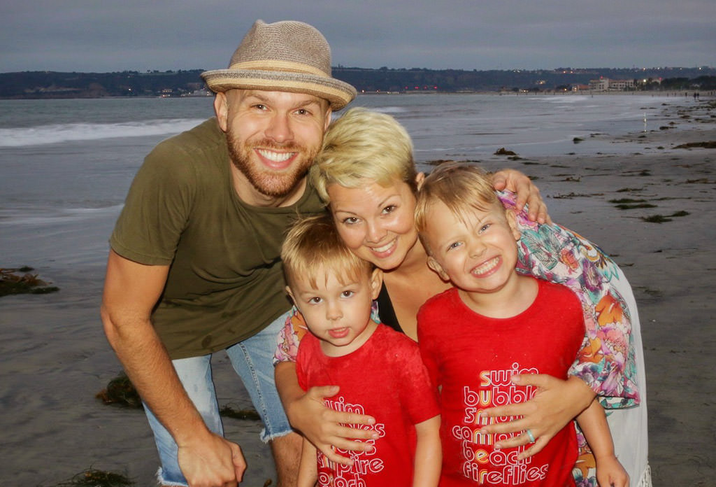 Nic, Jess, Bailey and Brady smiling on a beach. 