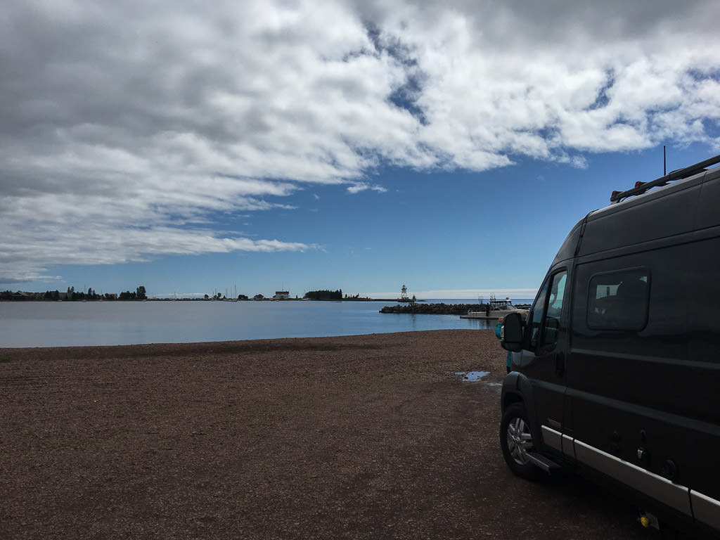 Winnebago Travato parked along the water.