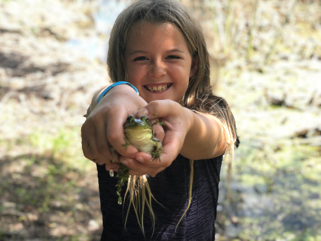 Melia holding out a frog