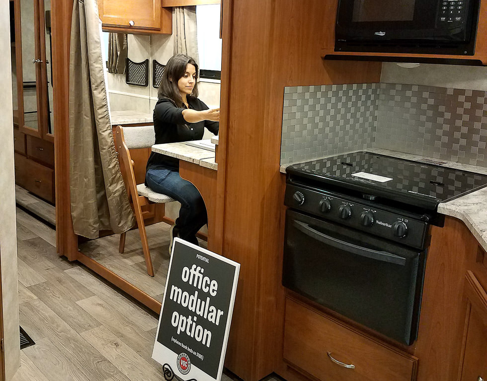 Nadia sitting in office modular option in Winnebago.