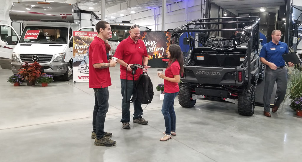 Kenny, Jon, and Nadia socializing among the product display.