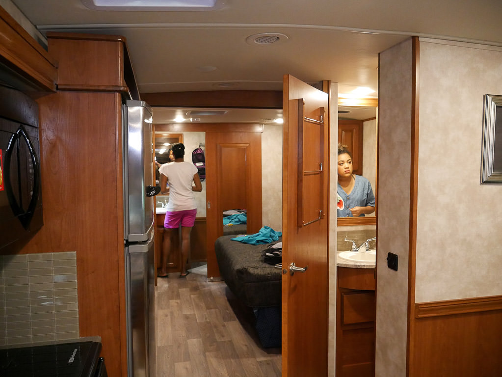 Sabrina and their niece both getting ready in the two bathrooms.