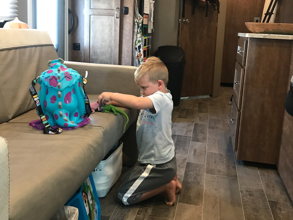 One of the kids playing with toys on the couch
