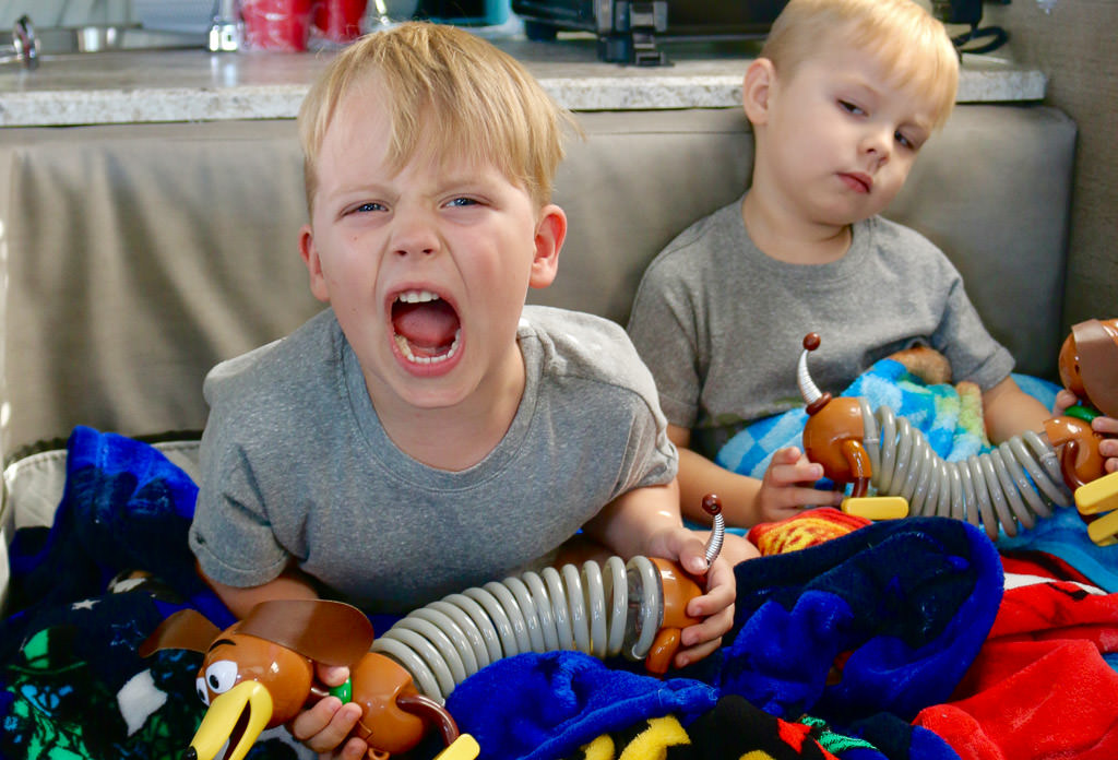 The kids playing with toys on the couch
