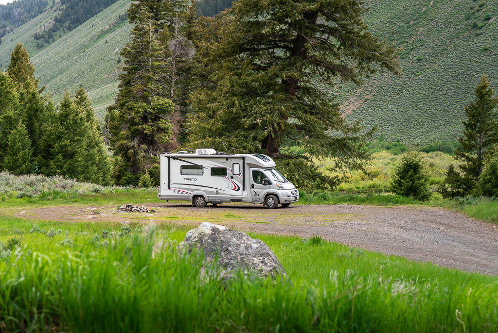 Trend parked in grass next to campfire made from rocks\
