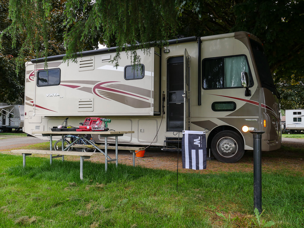 Full exterior passenger view of a Winnebago Vista in camp