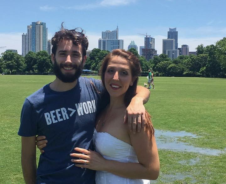 Couple smiling with the city skyline of Austin in the background.