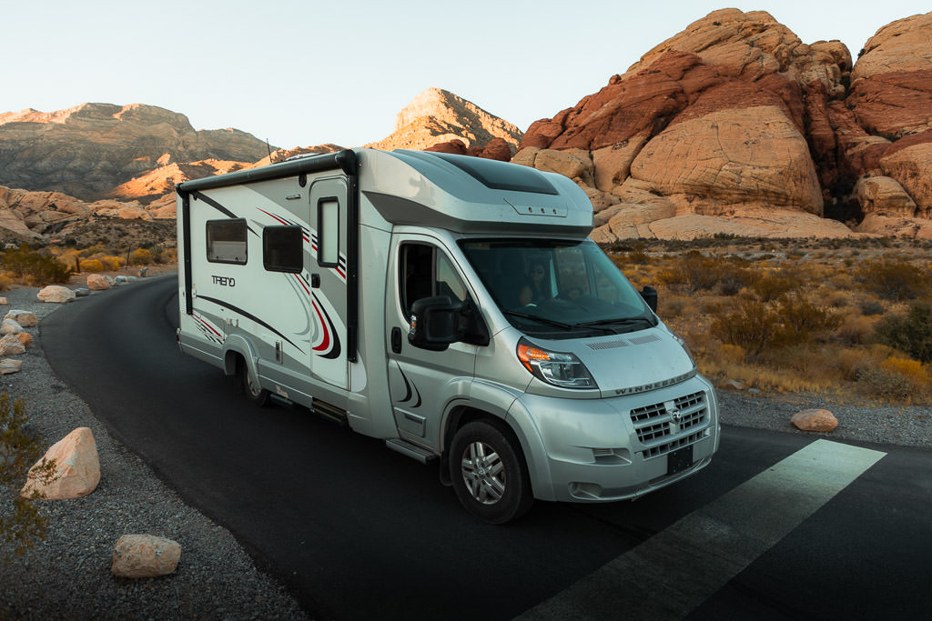 Winnebago Trend parked on paved road with rock formations in the background.