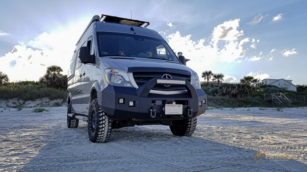 Winnebago Revel parked on a sandy beach.